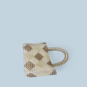 Detail of handmade beaded tote bag featuring a brown diamond weave pattern and top handle