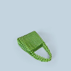 Detailed top view of handmade emerald green beaded handbag with glossy woven bead texture
