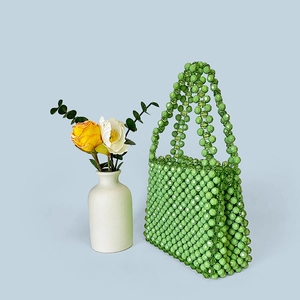 Detailed side view of handmade green beaded handbag with intricate woven bead textures