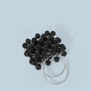 Detail of black beaded handbag featuring triple silver metal rings handle and inner lining