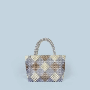 Detail of handmade beaded tote with geometric diamond pattern and woven top handles