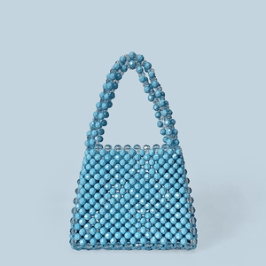 Detail of light blue handmade beaded handbag with faceted acrylic beads and woven handle