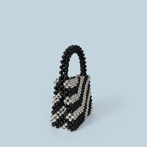 Close-up of handmade beaded bucket bag with black and silver diagonal stripes