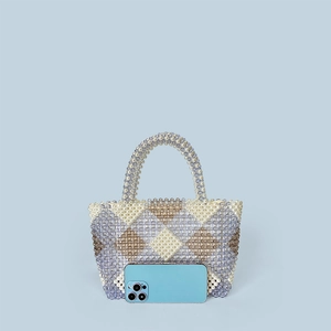 Detail view of handmade beaded tote bag with geometric pattern and phone for scale