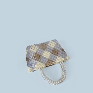 Macro shot of handcrafted checkered bead patterns on a stylish large capacity tote bag
