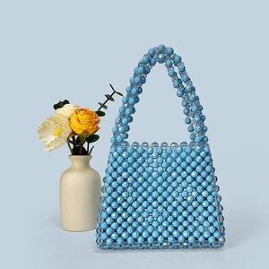Detail view of light blue beaded handbag with faceted crystal-like texture and top handle