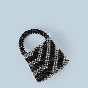 Detail of handmade woven bucket bag featuring black and silver beads in a striped pattern