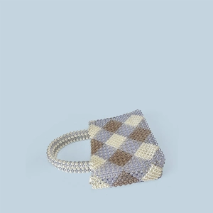 Detailed view of handmade beaded tote bag with geometric blue and white patterns