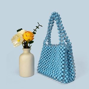 Close-up of handmade light blue beaded handbag with faceted acrylic beads and dual handles