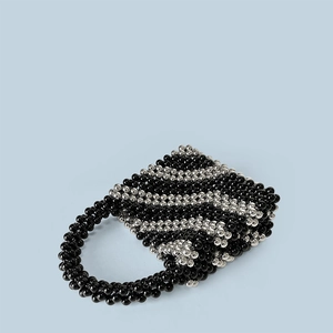 Detail showing the intricate hand-woven black and silver bead texture of the bucket bag