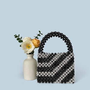 Detailed view of handmade beaded bucket bag with striped black and silver pearls