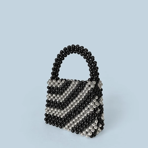 Macro shot of handcrafted black and silver beaded texture on a stylish bucket bag