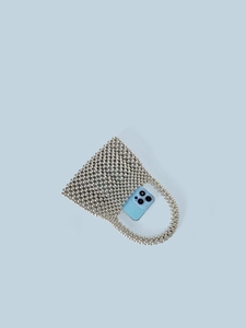 Sac à main argenté perlé effet métallique contenant un téléphone pour l'échelle réelle