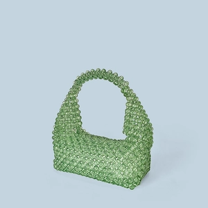 Macro shot of light green beaded tote bag showcasing intricate woven acrylic bead texture