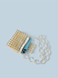 Sac à bandoulière fait main en perles dorées et blanches avec chaîne sur fond bleu