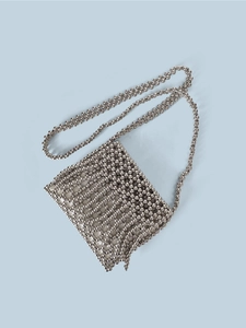 Detailed view of silver metallic beaded crossbody bag with hand-woven mesh texture
