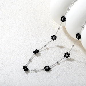 Détail du collier chaîne argenté avec fleurs en cristal noir et perles métalliques