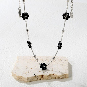 Détail du collier à fleurs noires perlées en acier inoxydable avec fermoir mousqueton