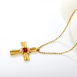 Collier croix dorée avec pendentif en zircon rouge rubis sur une chaîne à billes chic