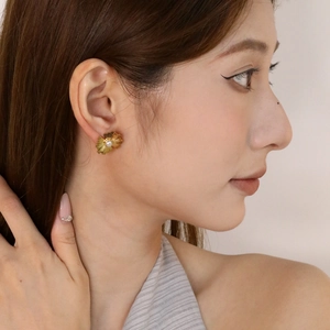 Detail von 18K Gold Blumenohrsteckern mit Perle am Model in der Seitenansicht