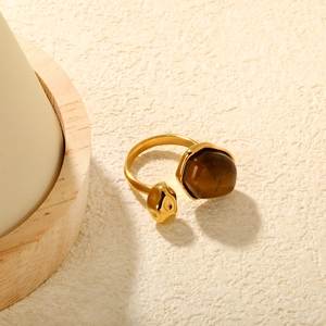 Détail de la pierre œil de tigre et de la bague en acier inoxydable doré à texture ondulée