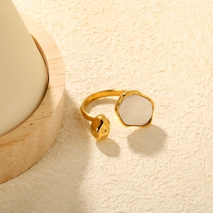 Détail d'une bague ouverte avec pierre œil de tigre irrégulière et perle dorée polie