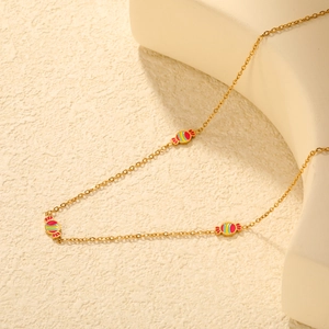 Detailed shot of gold chain necklace featuring three colorful striped candy charms