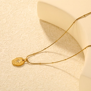 Collier à pendentif étoile dorée avec zircon sur une chaîne serpent à perles