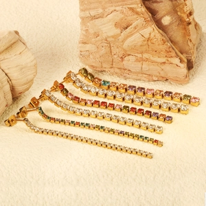 Elegant gold-plated dangle earrings with colorful zircon tassels on natural stone decor