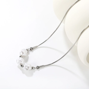 Detail of silver snake chain necklace featuring three white baroque irregular pearls