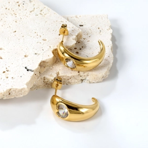 Detail of C-shaped 18K gold plated earrings with sparkling round white zirconia stones