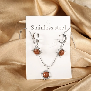 Parure de bijoux vintage en acier inoxydable avec pierres de soleil sur fond satiné