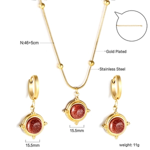 Gros plan d'un ensemble de bijoux en acier doré avec pendentifs en grès rouge