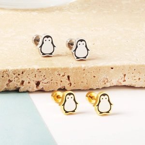 Detailed view of cute penguin stud earrings in gold and silver with enamel finish