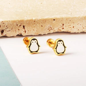 Detail view of 18K gold plated stainless steel penguin stud earrings with enamel design