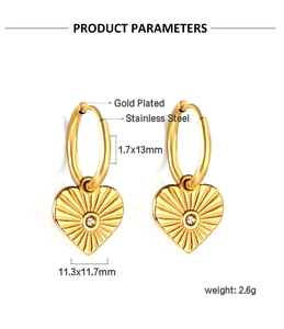 Détail des boucles d'oreilles cœur dorées avec texture rayon de soleil et zircone