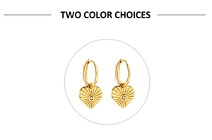 Détail de boucles d'oreilles cœur doré avec texture rayon de soleil et petit cristal