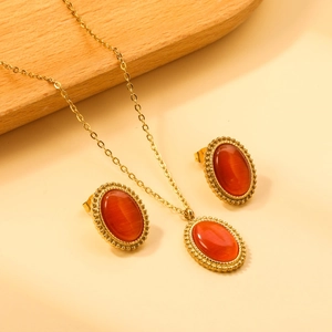 Detail of vintage gold necklace and opal earrings set with red oval stones