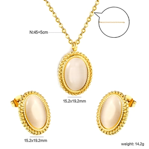 Detailed view of white oval opal pendant and earrings set with gold beaded border