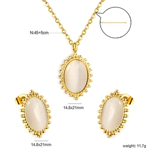 Detail view of oval cat's eye stone jewelry set with intricate golden beaded frame