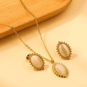 Detail of vintage opal jewelry set with golden lace oval pendant and matching earrings
