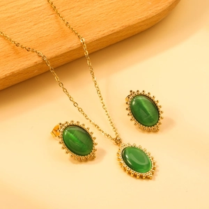 Detailed macro view of gold-plated necklace and earrings set with green cat eye stones