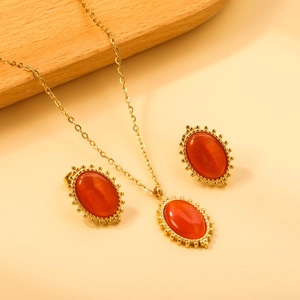 Detailed view of oval orange cat-eye stone jewelry set with gold beaded edges