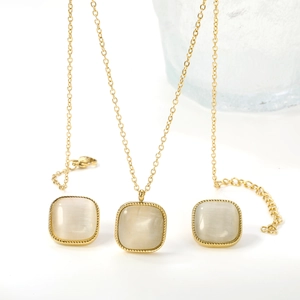 Détail de parure vintage avec pendentifs carrés œil de chat et cadres dorés