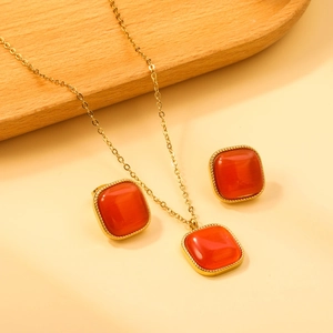 Détail de la bordure torsadée dorée et de la pierre œil-de-chat orange sur les bijoux
