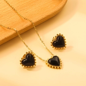 Detail of vintage heart jewelry set with black pendants and beaded gold borders