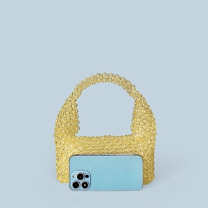 Detailed view of yellow handmade beaded tote bag compared to a smartphone for size scale