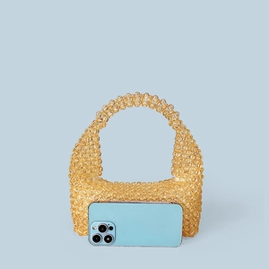Handmade yellow beaded tote bag shown next to a smartphone for size reference