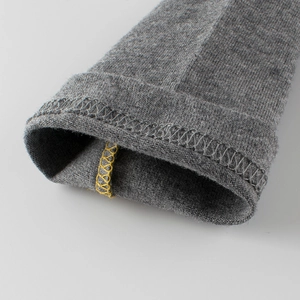 Nahaufnahme des grauen Langarm-Shirts mit feiner Stricktextur und gelber Kontrastnaht