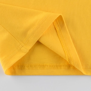 Nahaufnahme des gelben Baumwoll-T-Shirt-Saums mit hochwertiger Doppelnaht für Kinder